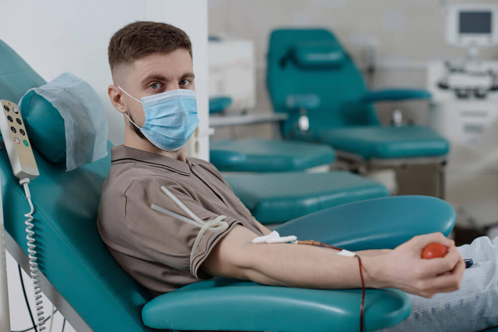 Patient dormant dans un fauteuil médical, symbolisant la fatigue après une perfusion de fer.