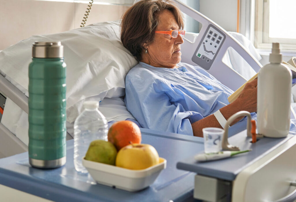 Patient se reposant dans un lit médicalisé avec une bouteille d'eau pendant sa convalescence