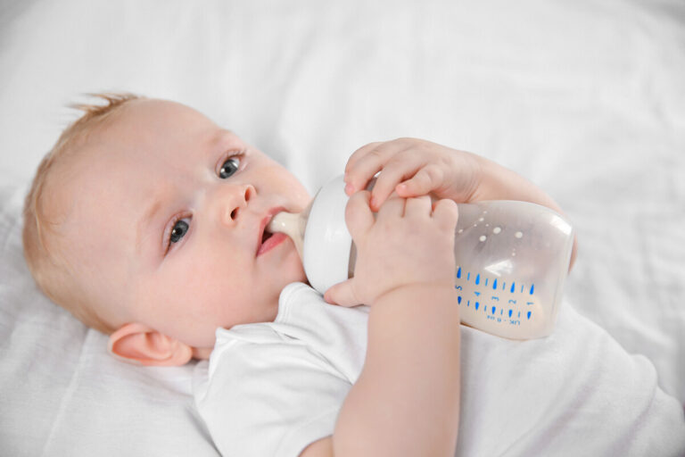 Bébé de 8 semaines buvant un biberon de grande contenance.