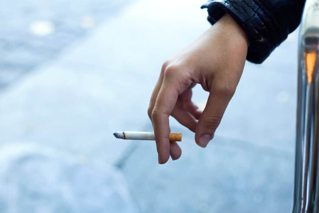 Zoom sur une cigarette industrielle détaillant la présence de substances nocives ajoutées lors de la fabrication.