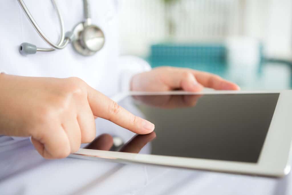 Présentation de données cliniques et de graphiques sur une tablette tactile lors d'un entretien à distance.
