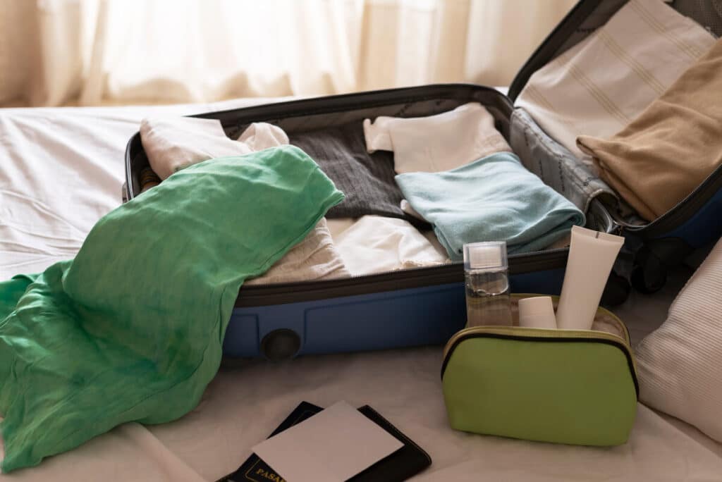 Une valise ouverte sur le sol d'une chambre d'hôtel, illustrant le principal vecteur de contamination et d'introduction des nuisibles lors des voyages.
