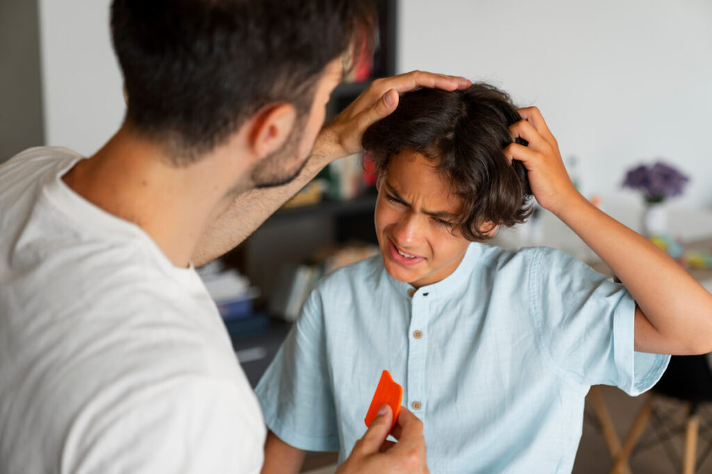 Un parent examinant attentivement la chevelure d'un enfant à la recherche de poux ou de lentes.