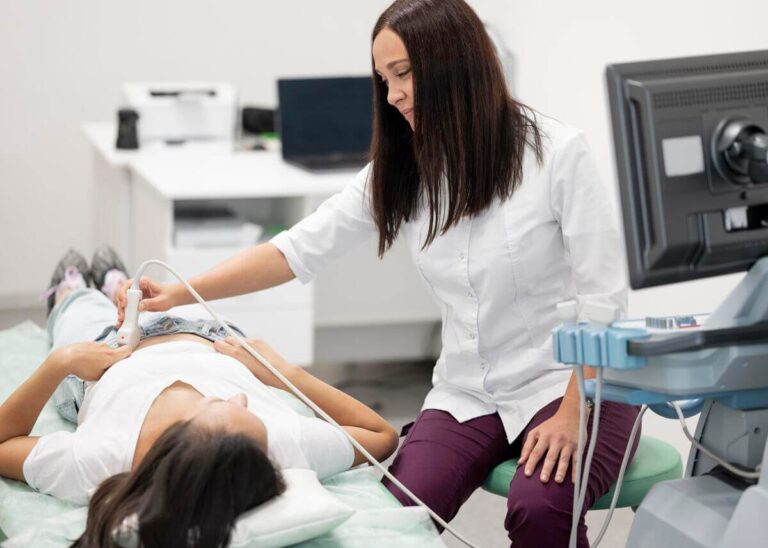 Accueil 2 Un médecin gynécologue réalisant une échographie de datation précoce en début de grossesse.