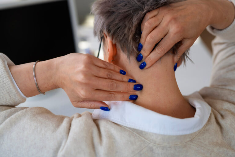 Accueil 4 Une personne massant doucement ses vertèbres cervicales pour calmer les spasmes musculaires involontaires du cou.