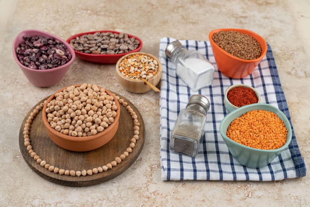Manque de fer : que manger pour augmenter naturellement ses apports ? 3 Des bols de lentilles, de pois chiches et d'épinards frais riches en fer végétal.