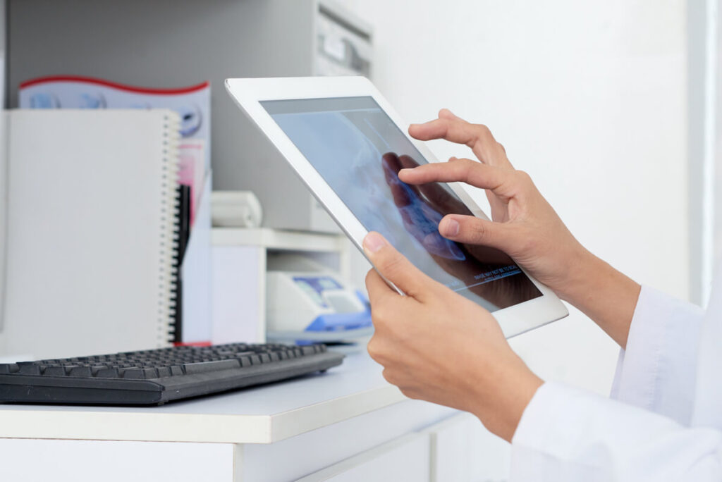 Un médecin utilisant un outil de mesure électronique sur une image d'IRM sur son écran.