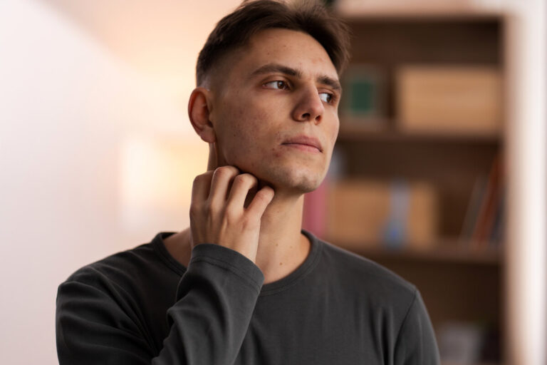 Accueil 1 Une personne touchant délicatement son cou, ressentant une gêne ou un chatouillement permanent dans la gorge.