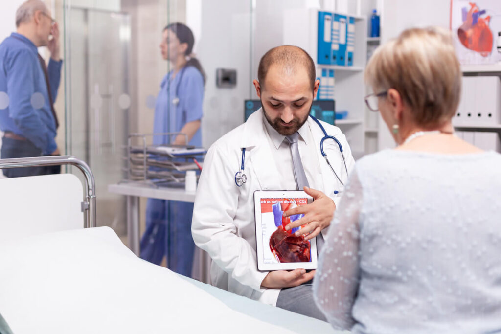 Un médecin gastro-entérologue expliquant un schéma de l'estomac et de l'œsophage.