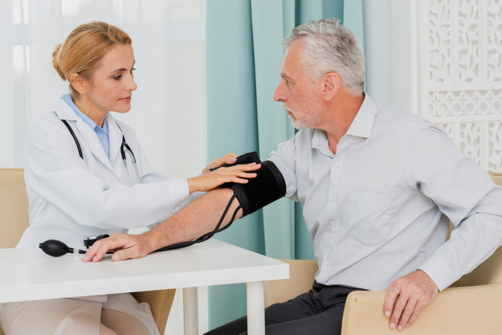 Subnormale : que signifie ce terme médical ? 3 Un médecin prenant la tension d'un patient à l'aide d'un brassard classique au cabinet.