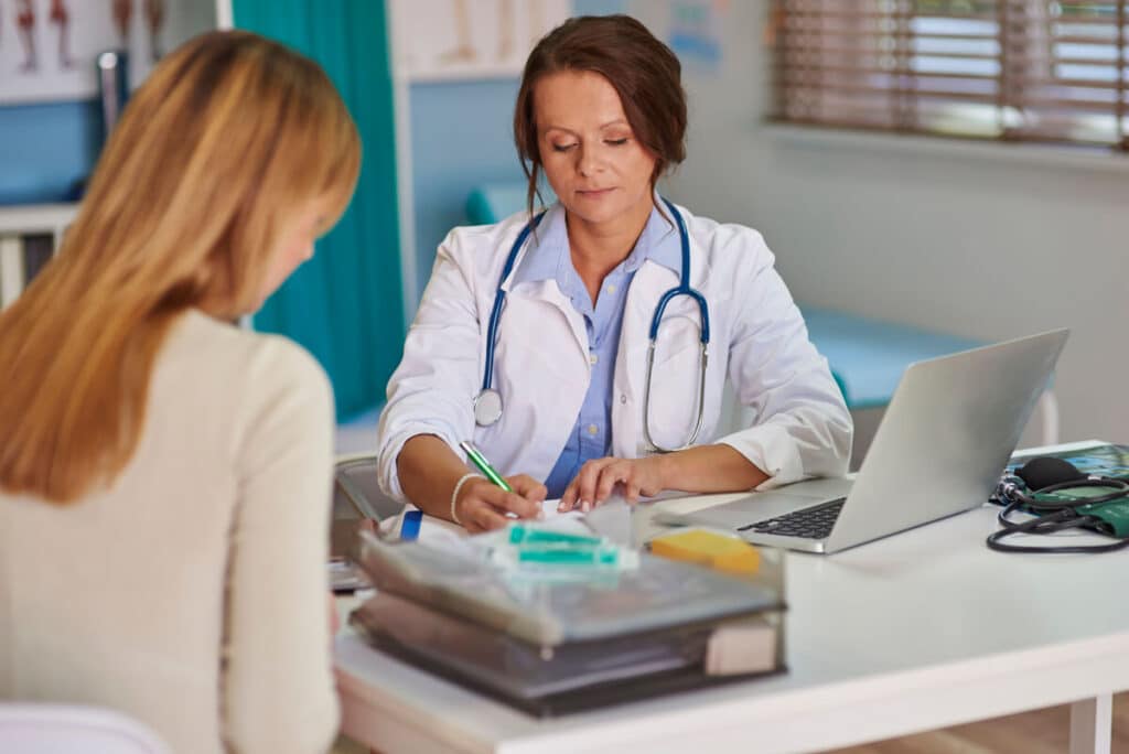 Un médecin spécialiste expliquant un protocole de soin à une patiente dans son cabinet.