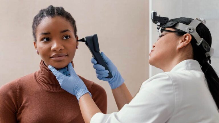 Accueil 1 Un médecin ORL examinant le tympan d'un patient adulte à l'aide d'un otoscope en cabinet.