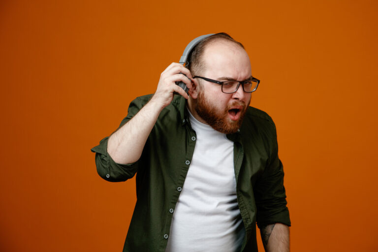 Une personne se tenant l'oreille avec une expression de gêne face à un sifflement auditif.