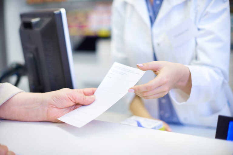 Accueil 1 Une ordonnance papier posée sur le comptoir d'une pharmacie lors d'une délivrance.