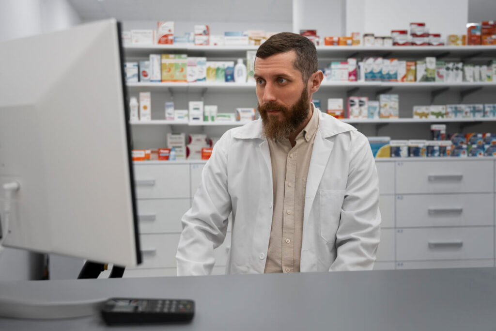 Peut-on utiliser une ordonnance dans plusieurs pharmacies différentes ? 3 Un pharmacien contrôlant la délivrance des médicaments sur son ordinateur.