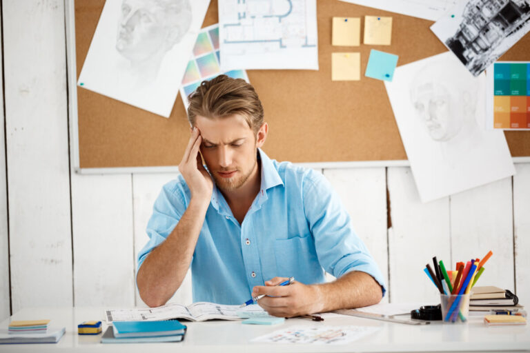 Un homme assis à son bureau, submergé par ses pensées, illustrant les difficultés de concentration du TDAH.Un homme assis à son bureau, submergé par ses pensées, illustrant les difficultés de concentration du TDAH.