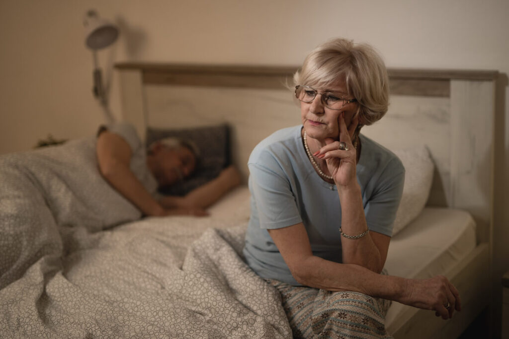 Quels sont les premiers signes de la ménopause à reconnaître ? 3 Une femme réveillée au milieu de la nuit dans son lit, illustrant l'insomnie hormonale.