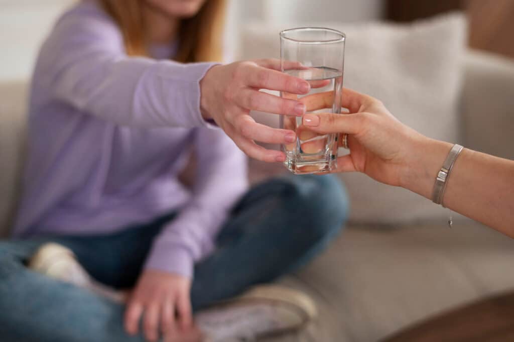 Verre d'eau et baskets pour remplacer le geste de la cigarette lors d'une envie passagère.