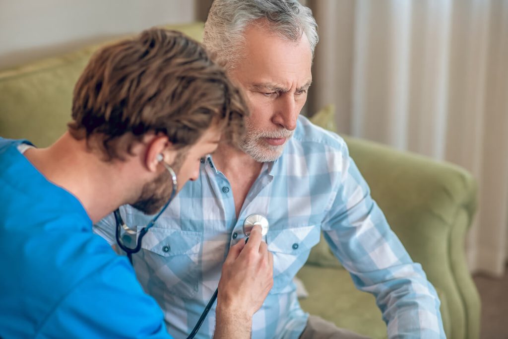 Bêta-bloquant et essoufflement : pourquoi et quand s'inquiéter 3 Cardiologue auscultant un patient pour adapter son traitement pour l'hypertension et le cœur.