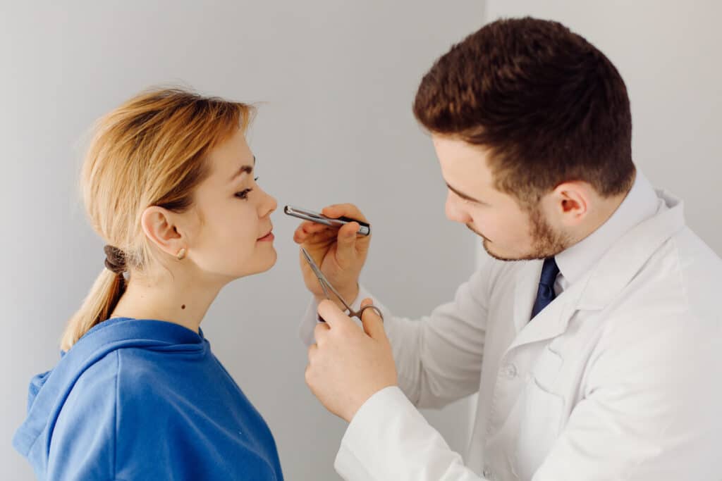 Médecin ORL examinant les fosses nasales avec un nasofibroscope.