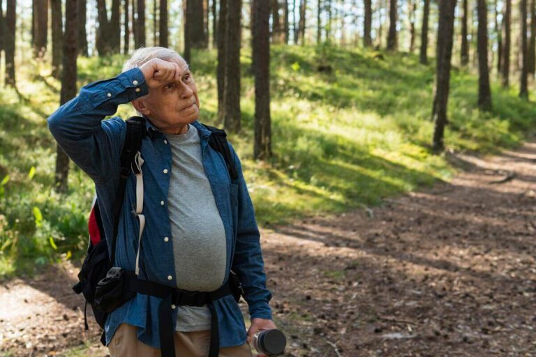 Personne âgée essoufflée reprenant son souffle lors d'une marche sous traitement bêta-bloquant.