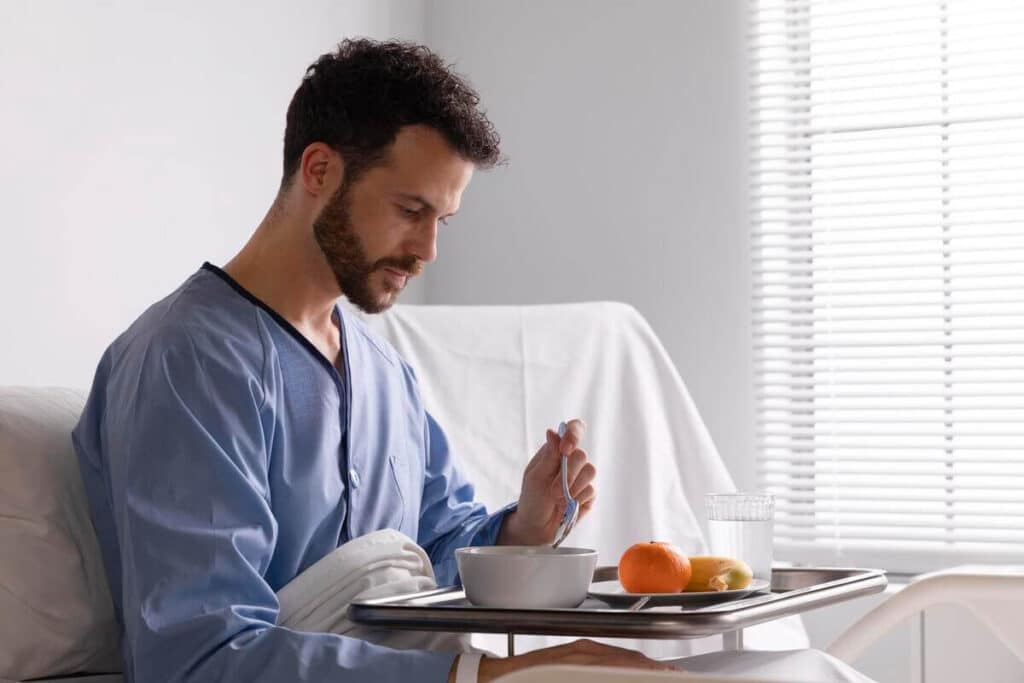 Patient prenant son comprimé de metformine au milieu d'un repas équilibré.