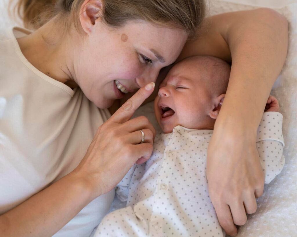 Nourrisson inconsolable pleurant dans les bras de son parent au milieu de la nuit.