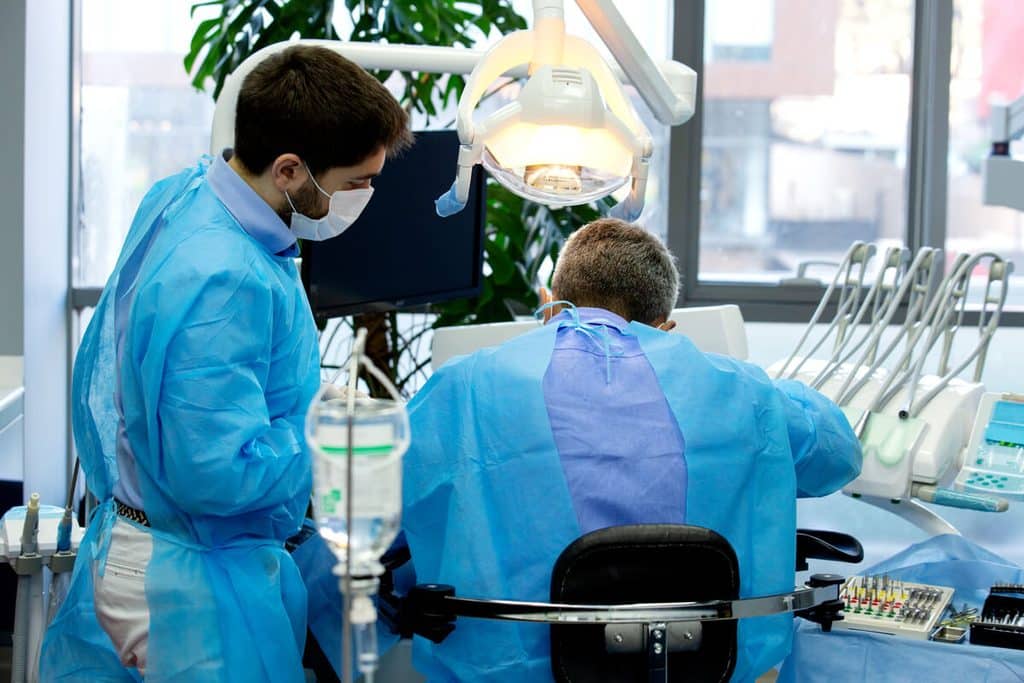 Chirurgien-dentiste préparant une anesthésie locale sécurisée pour une patiente enceinte.