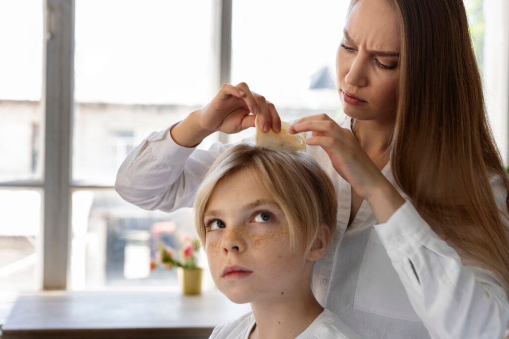 Parent inspectant mèche par mèche les cheveux d'un enfant pour repérer des poux et des lentes.