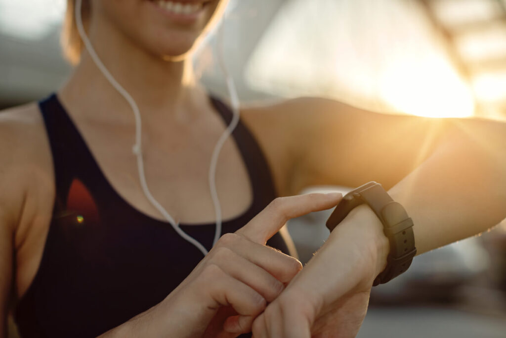 Écran d'une montre connectée affichant le rythme cardiaque en temps réel au poignet d'une personne.