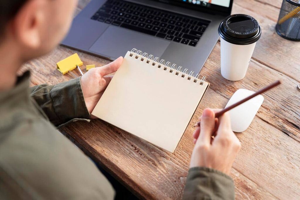 Carnet de notes ouvert sur une table pour découper ses tâches quotidiennes en micro-actions faciles.