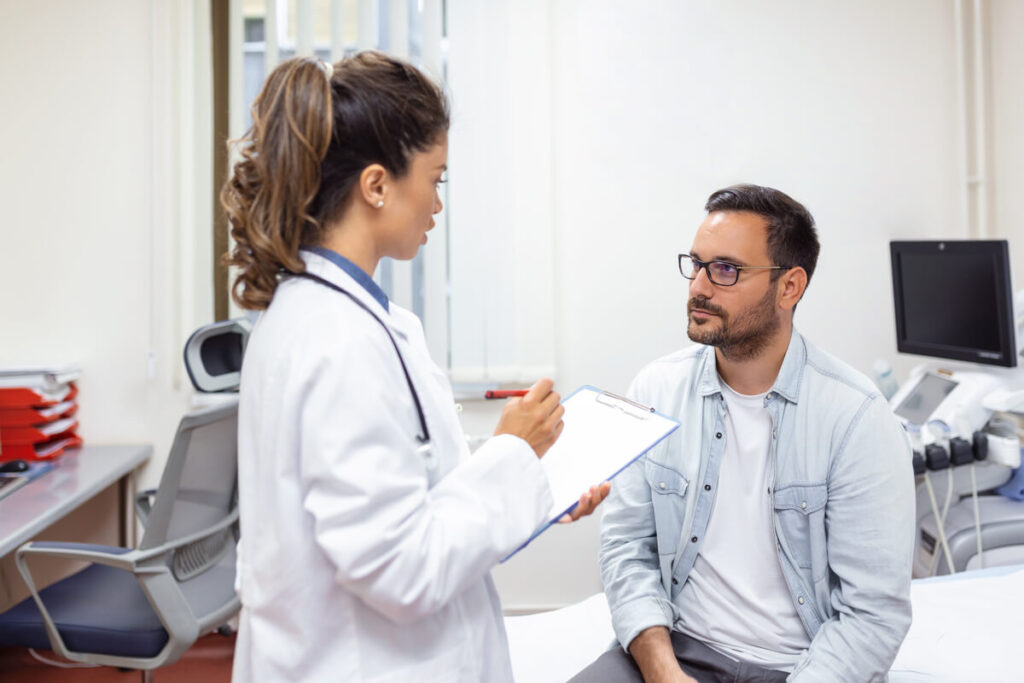 Médecin urologue en consultation écoutant un patient pour faire le bilan de troubles de l'érection.