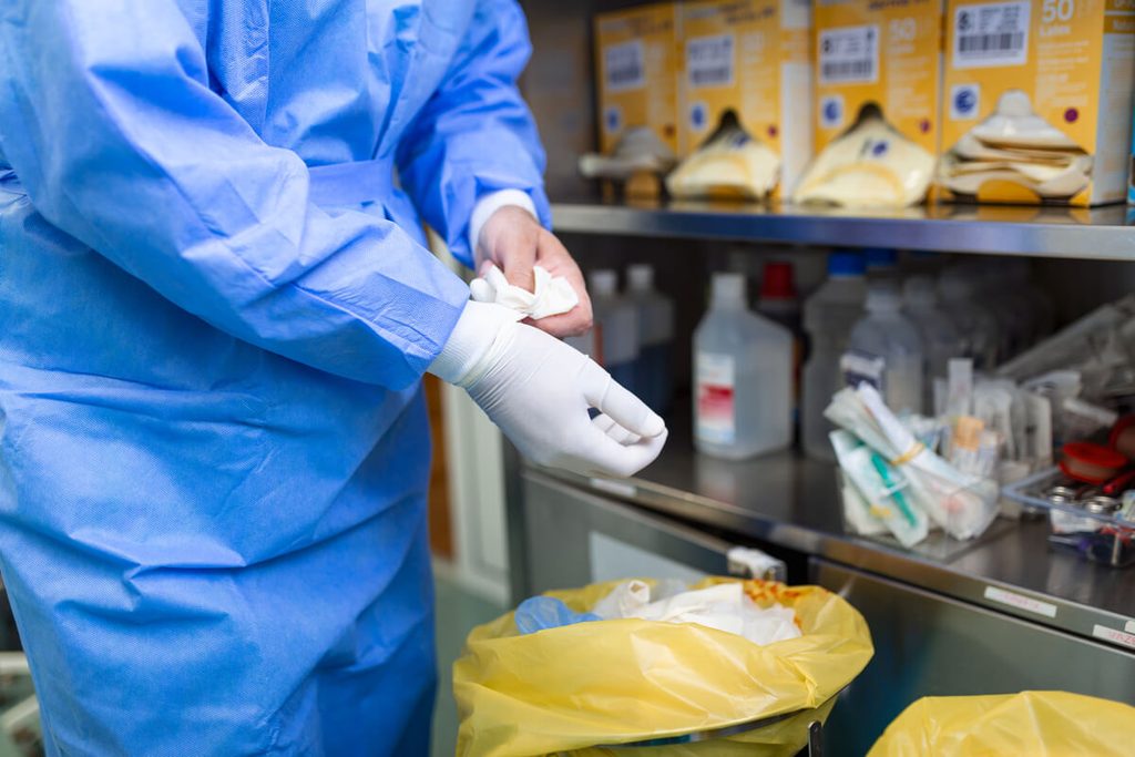 Comment bien jeter ses déchets de soins à la maison ou en établissement ? 3 Conteneurs jaunes fermés hermétiquement pour l'évacuation des déchets d'activités de soins dans un local hospitalier.