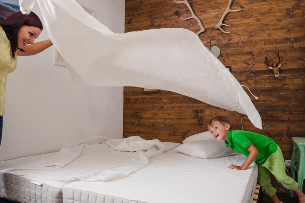 Housse intégrale blanche anti-acariens zippée avec rabat d'étanchéité posée sur un matelas pour personne asthmatique.