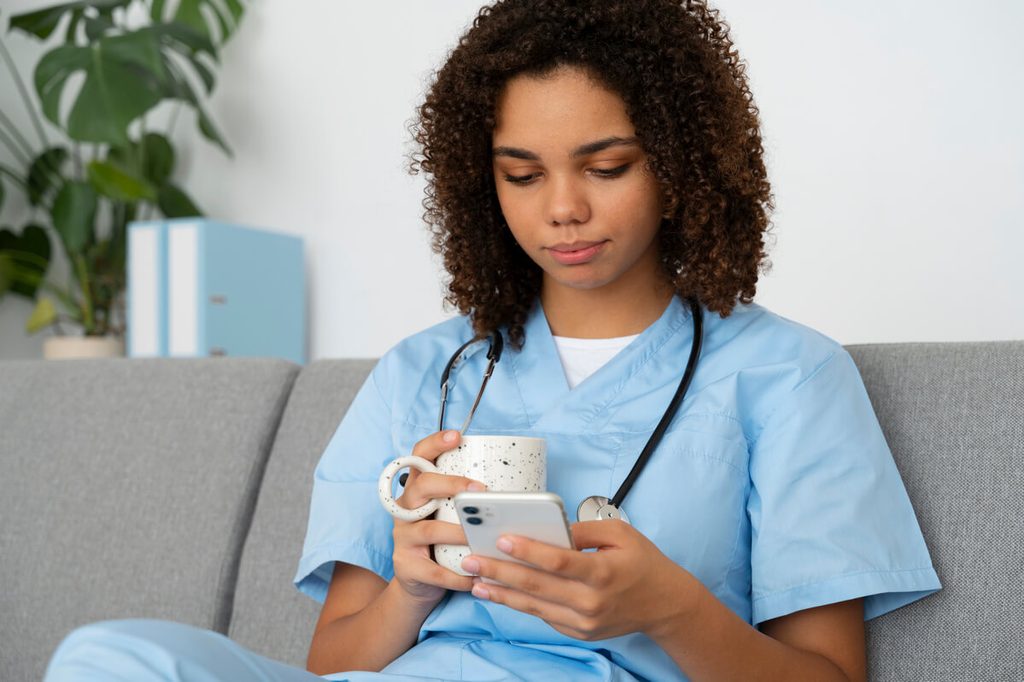 Les critères de choix d'un logiciel pour infirmier et infirmière libérale 3 Infirmière libérale consultant le dossier de soins d'un patient sur smartphone pendant sa tournée.