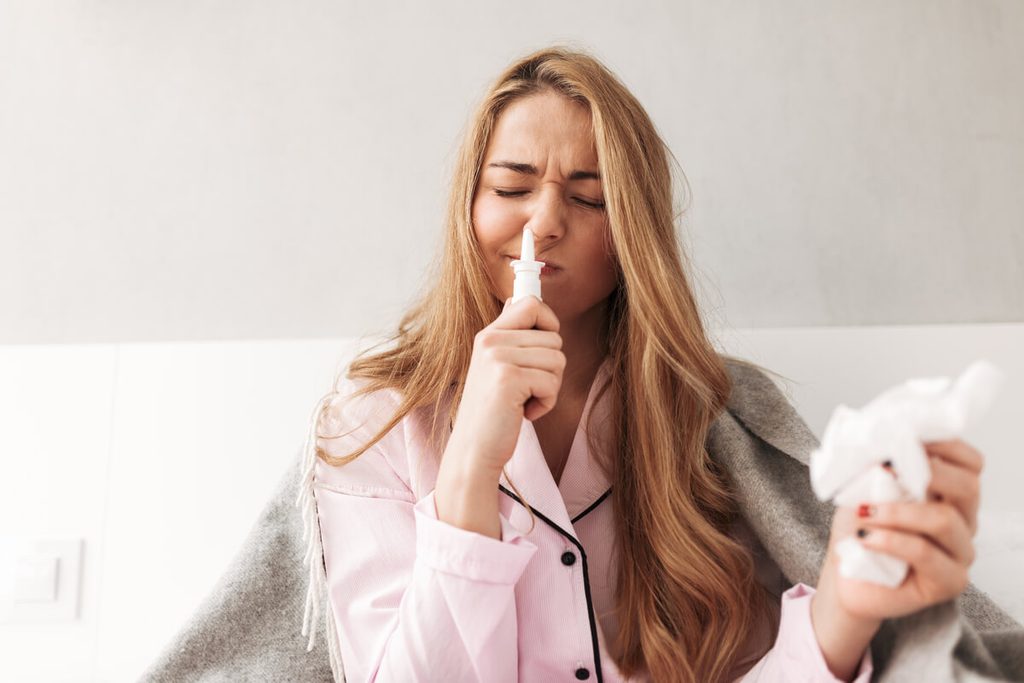 Syndrome du nez vide : témoignage de patients, symptômes et avis de la HAS 4 Patient utilisant un spray nasal hydratant pour apaiser la sécheresse extrême de sa muqueuse respiratoire.